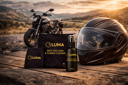 LUMA anti-fog lens and screen cleaner with a helmet and motorcycle in the background.
