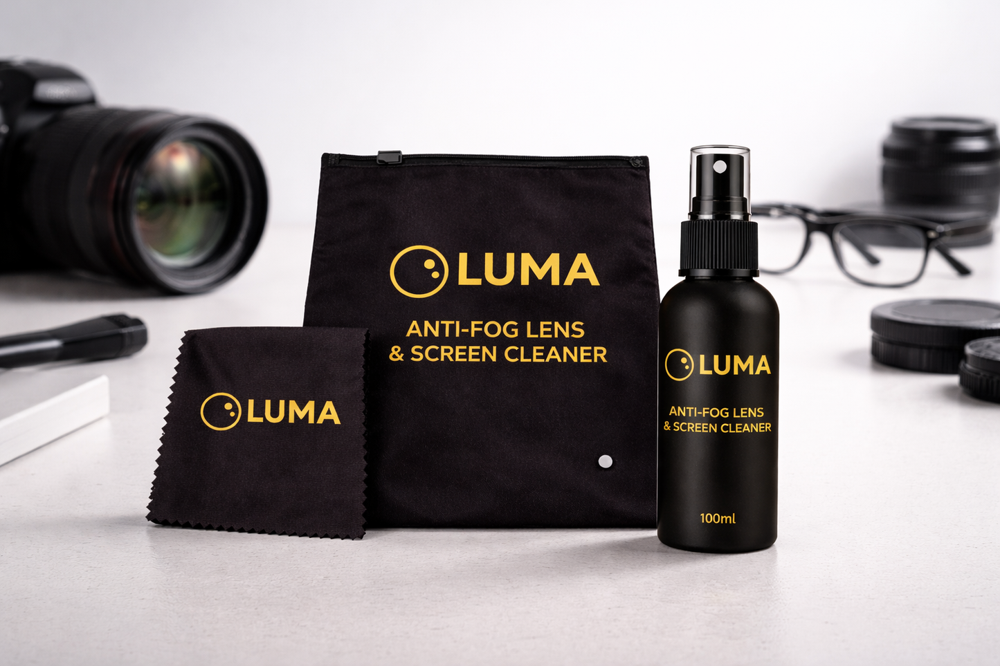 Luma anti-fog lens and screen cleaner set with spray bottle, cloth, and pouch on a white surface.